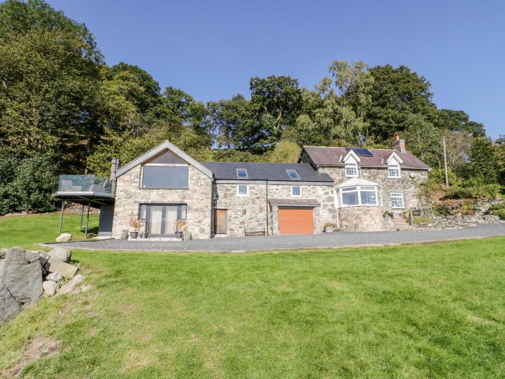 una grande casa in pietra con un vialetto d'accesso di Tyn Llwyn a Gwyddelwern
