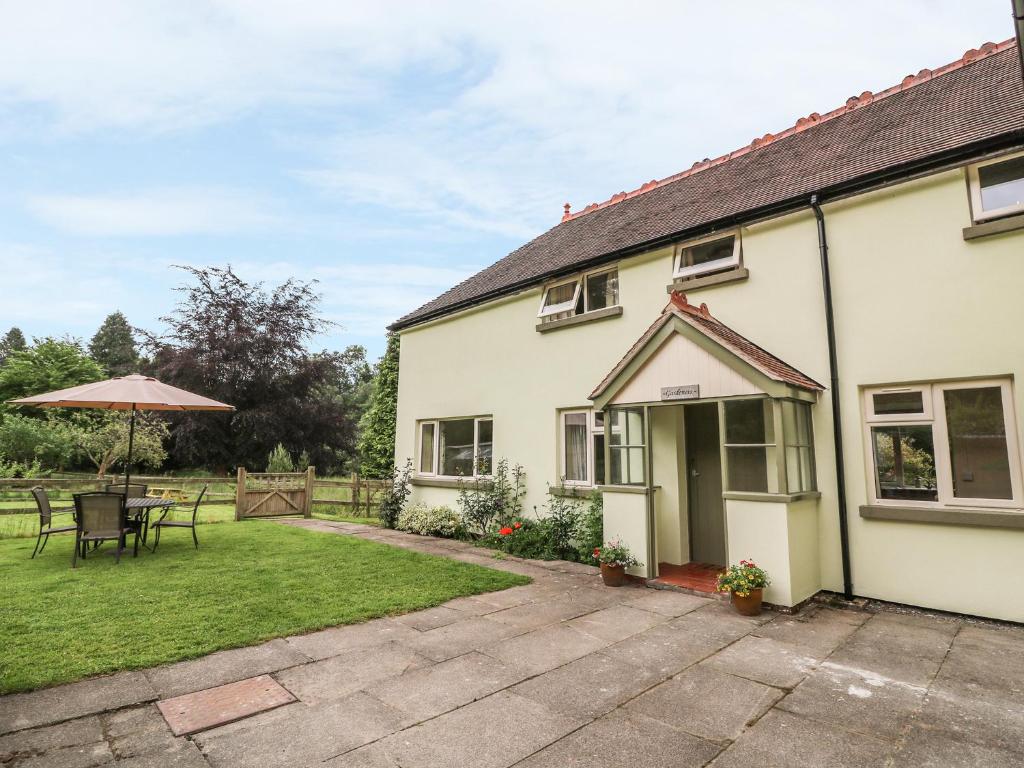 an exterior view of a house with a patio at Gardener's Cottage in Llandrindod Wells