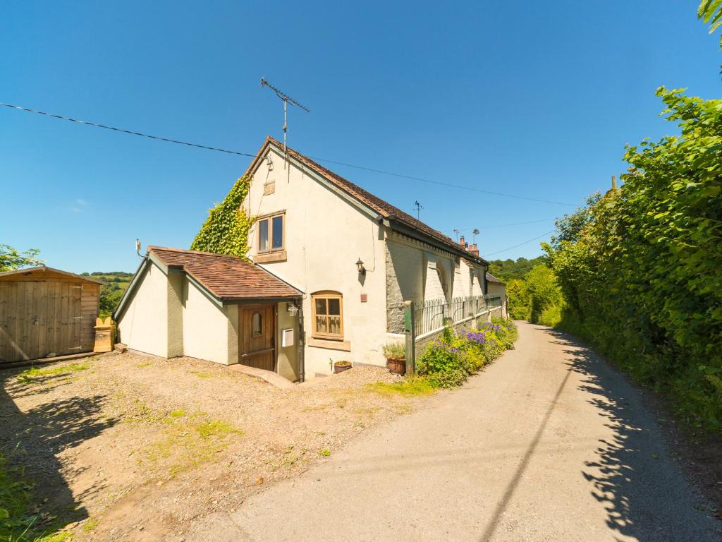 a small white house with a road next to it at The Old Chapel in Shelve