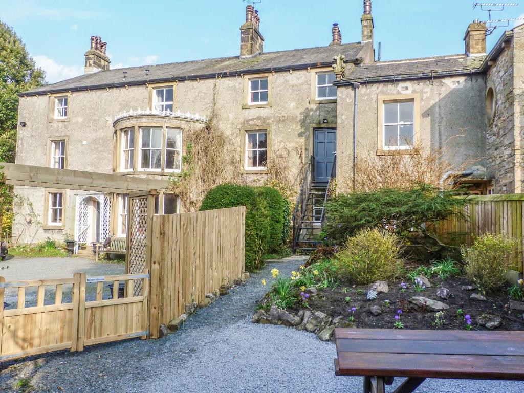 an old house with a wooden fence and a bench at Whitefriars Lodge in Settle