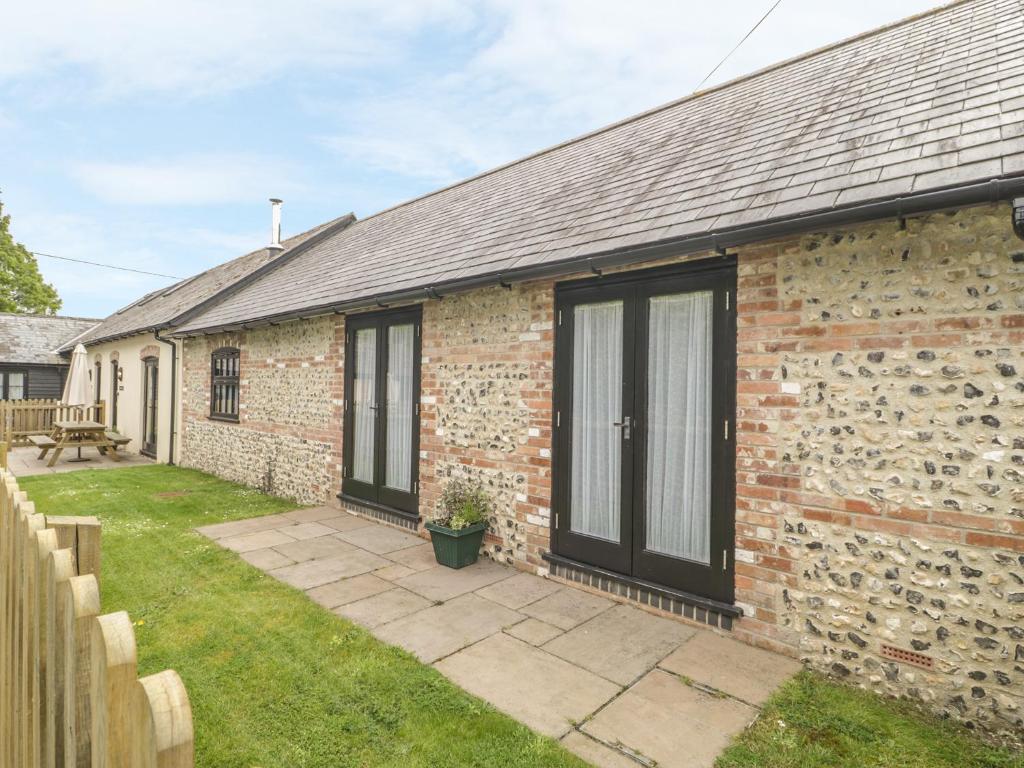 an exterior view of a brick house with a patio at The Old Cart Shed in Blandford Forum