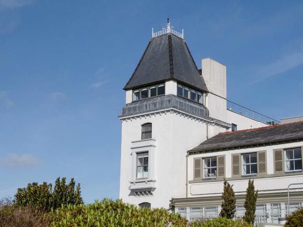 a white building with a tower on top of it at The Moorings in Conwy