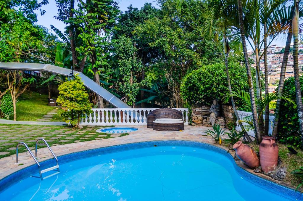 una piscina en un patio con un tobogán en Hotel Pousada Arcádia Mineira, en Ouro Preto