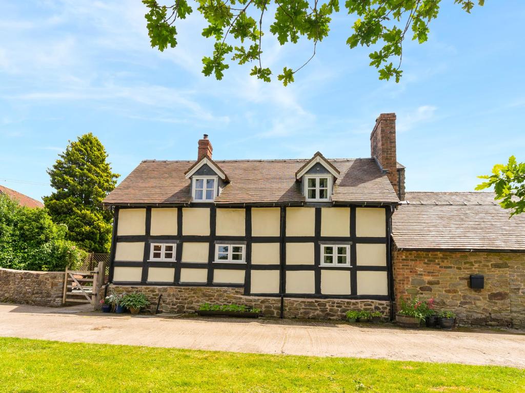 an old black and white house with a stone wall at Stone House in Ludlow