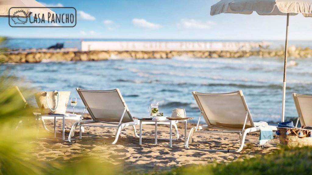 einen Tisch und Stühle am Strand mit Meerblick in der Unterkunft Apartamento Milla de oro 5 Personas in Marbella