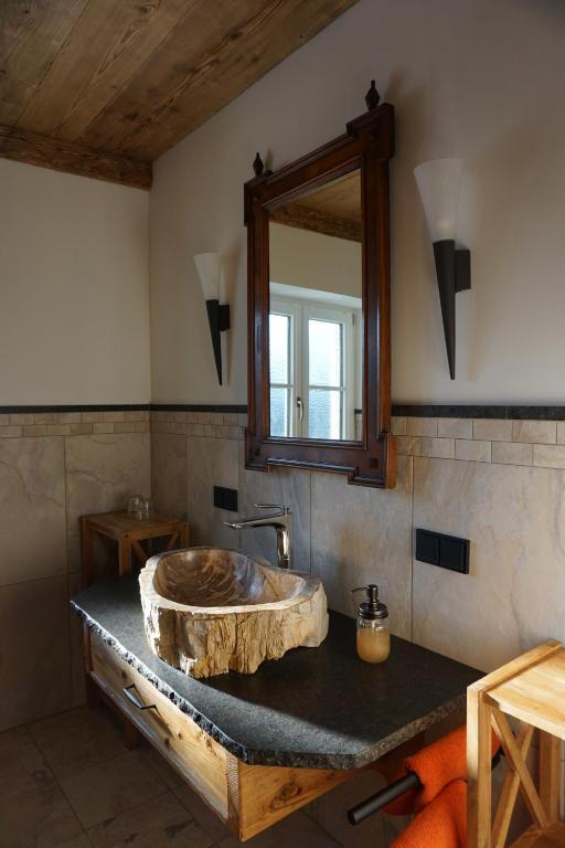 y baño con lavabo de piedra y espejo. en Jagerdichtlgut, en Altaussee