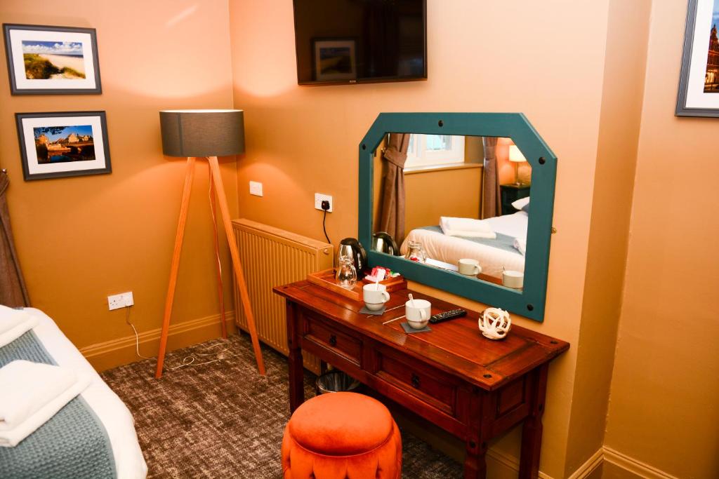 a bedroom with a mirror and a table with a bed at Plough Inn in Morpeth