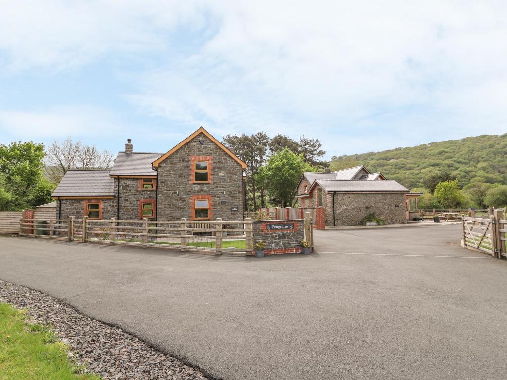 a house with a wooden fence in front of it at The Farmhouse in Capel Bangor