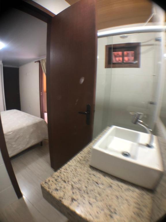 un bagno con un lavandino e un letto in una stanza di Linda casa com piscina em Bombinhas, espaço inteiro a Bombinhas