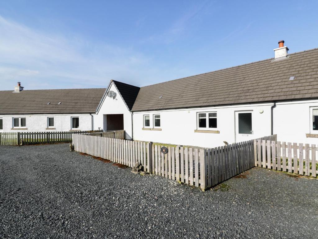 a white house with a fence in front of it at Starfish Cottage in Craignure