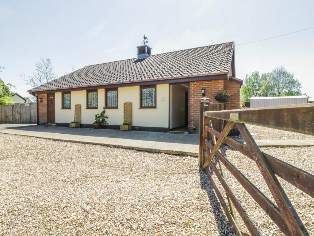 a house with a fence in front of it at Kingfisher in Wattisfield