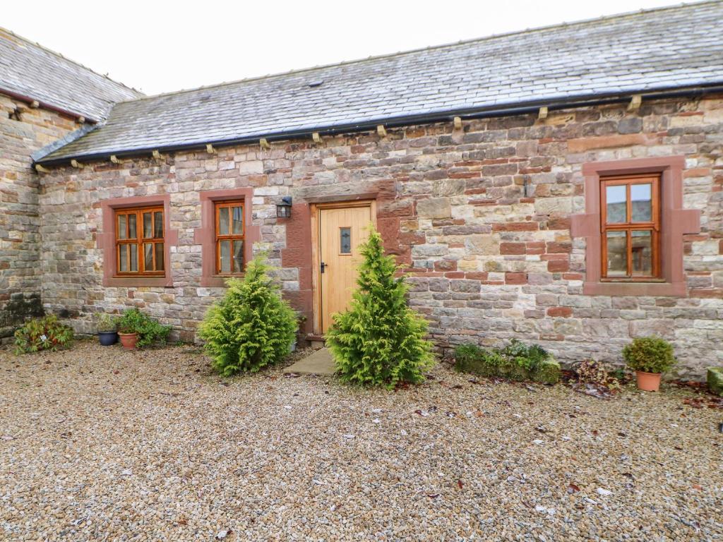 a stone house with two christmas trees in front of it at Dove Cottage in Brampton