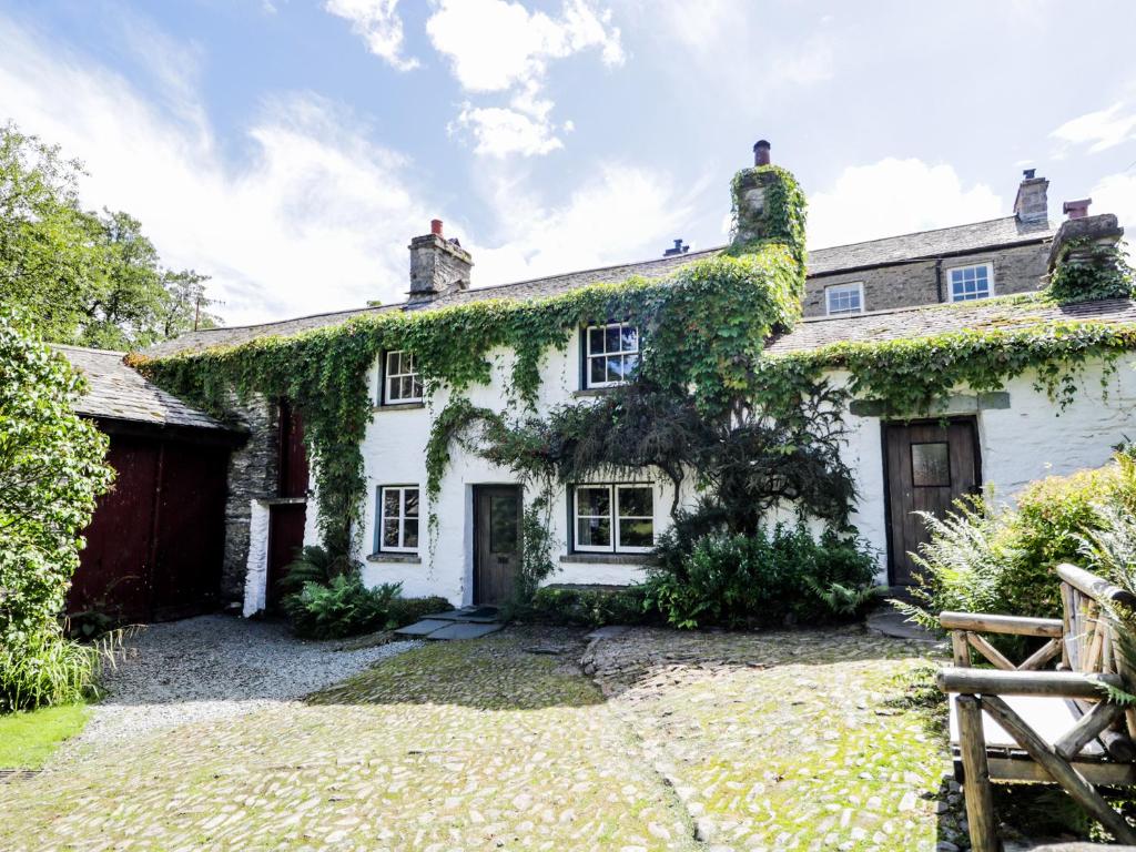 an exterior view of a white house with ivy at Mill Cottage in Staveley