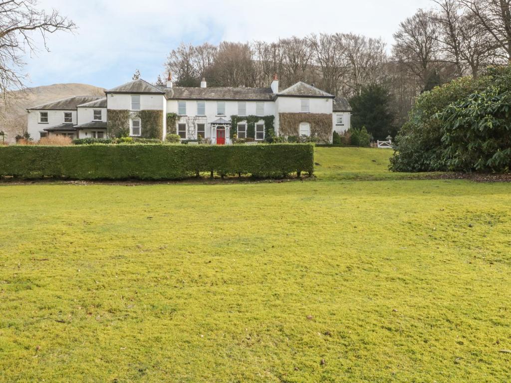 a large grassy field in front of a house at Thirlmere Suite in Thirlmere