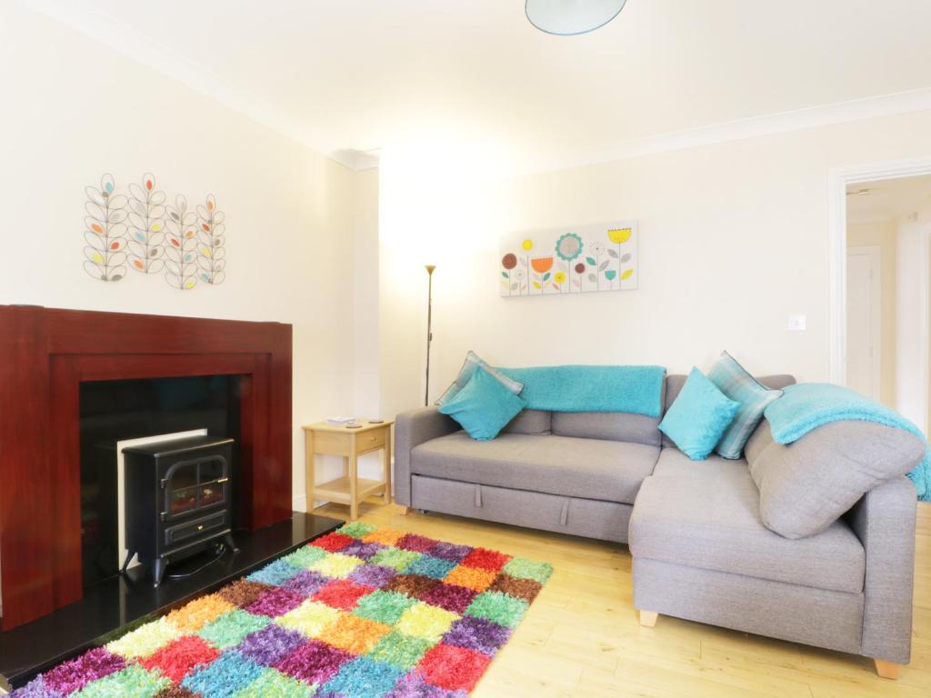 a living room with a couch and a fireplace at Fox's Den in Keswick