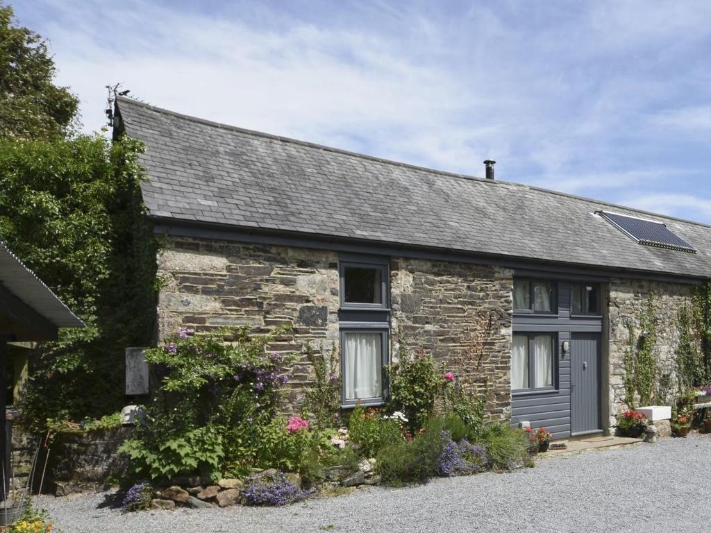 una casa de piedra con techo gris en The Stone Barn Cottage, en Holne