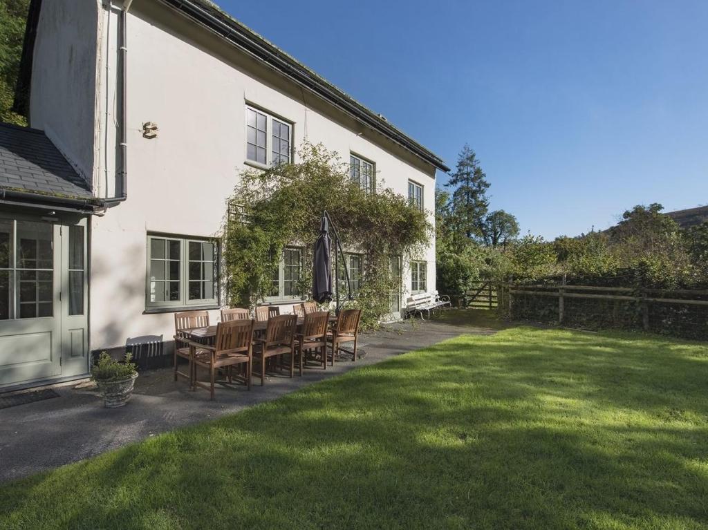 a house with a table and chairs in the yard at Barn Cottage in Hawkridge