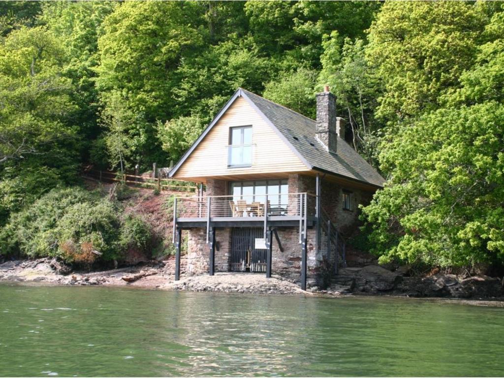 a house sitting on the side of a river at Sandridge Boathouse in Stoke Gabriel