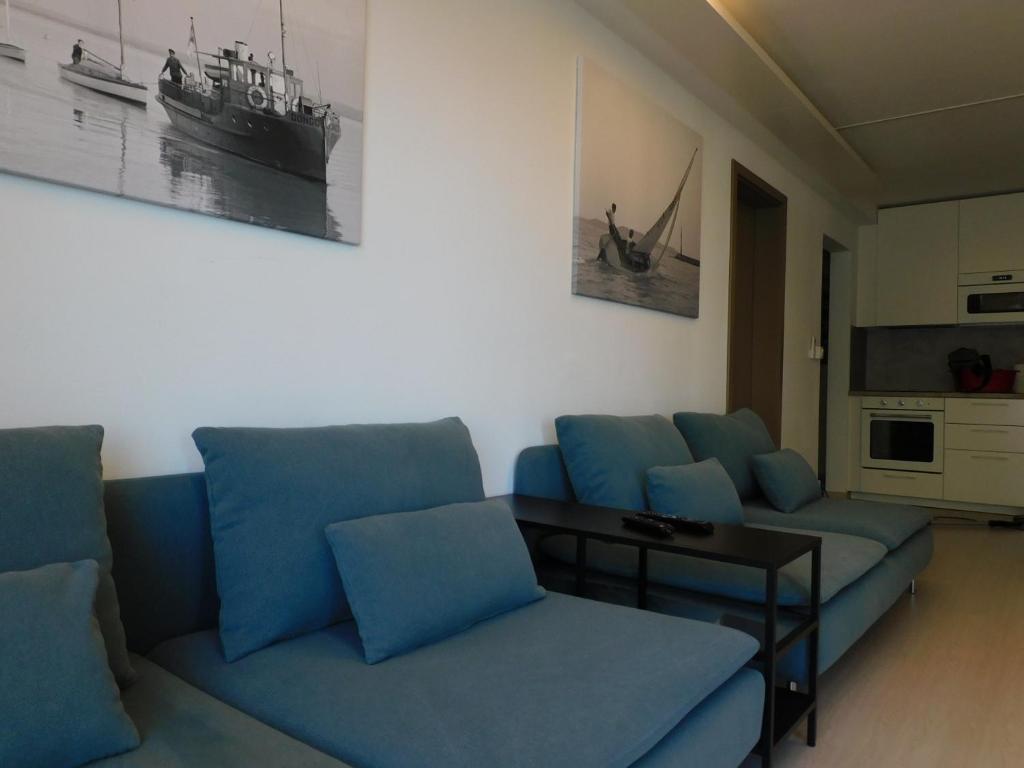 ein Wohnzimmer mit blauen Sofas und einem Tisch in der Unterkunft K&K Apartment Siófok in Siófok