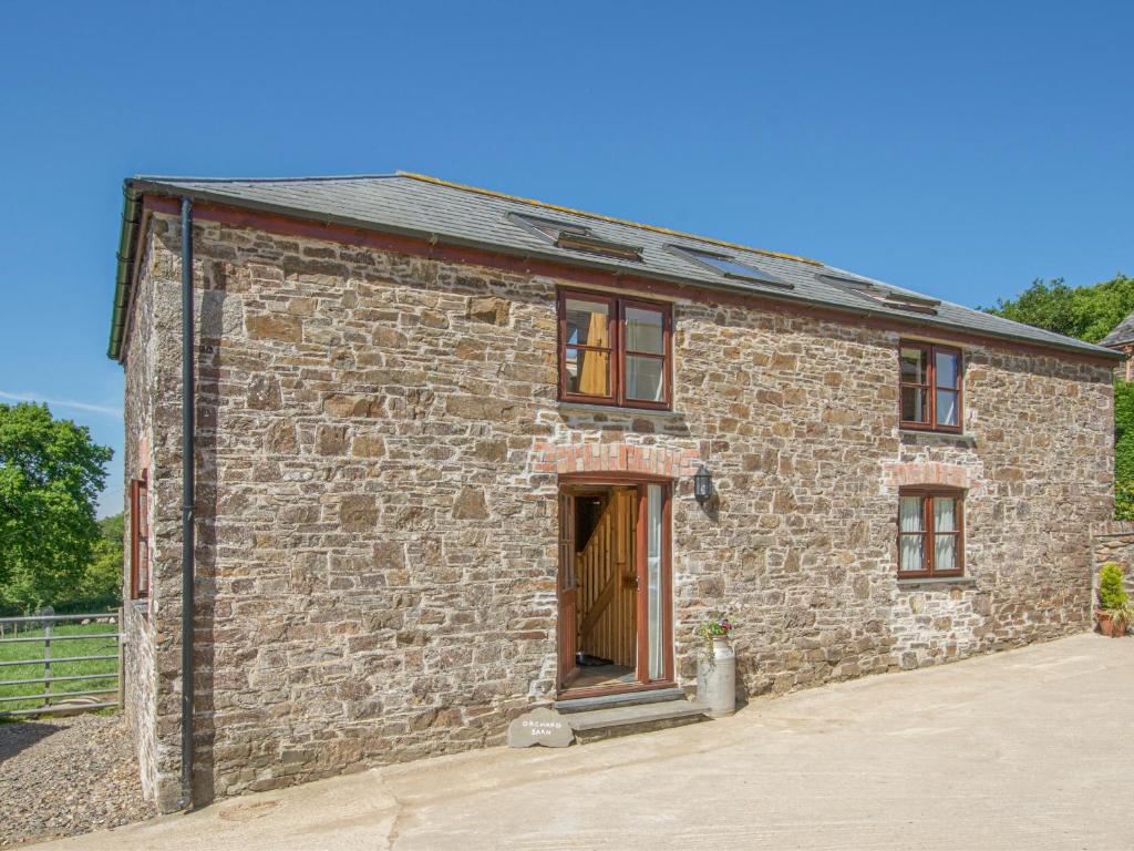 a small brick building with a door on it at Orchard Barn in Virginstow