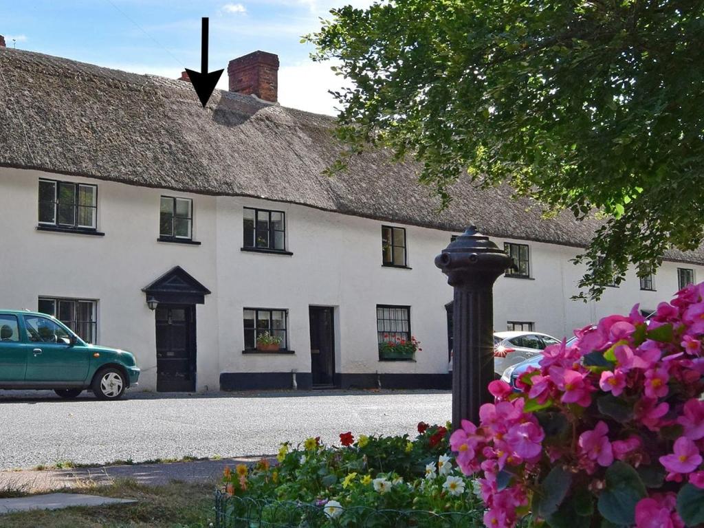 a white building with a black street light and flowers at 11 The Green in Budleigh Salterton