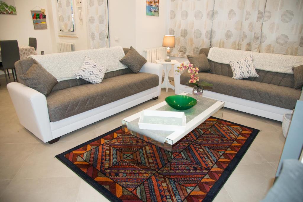 a living room with two couches and a table at MONDELLO MANICK MARE in Palermo