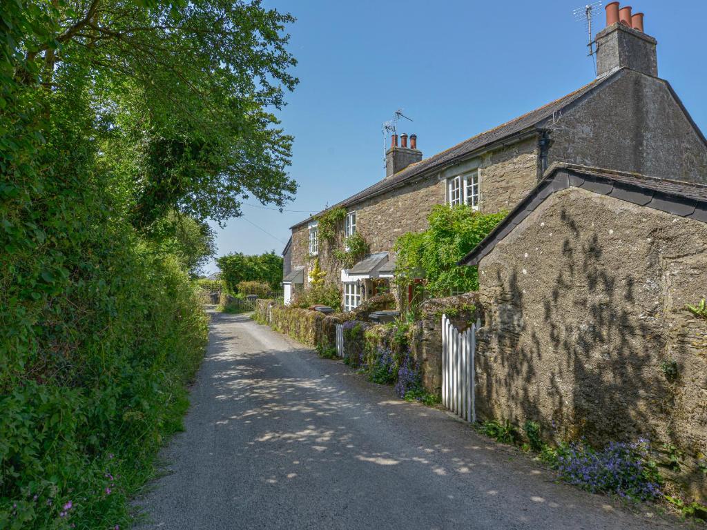 uma velha casa de pedra ao lado de uma estrada em 1 Gabberwell Cottages em Kingston