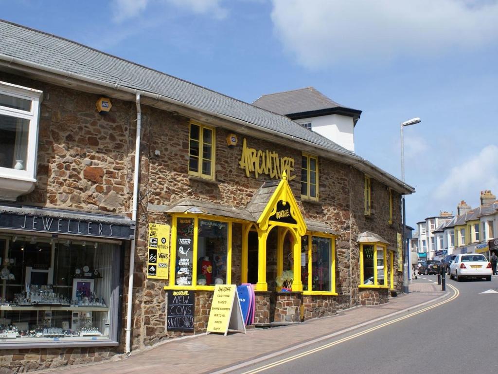 a brick building with yellow windows on a street at The Workshop in Bude