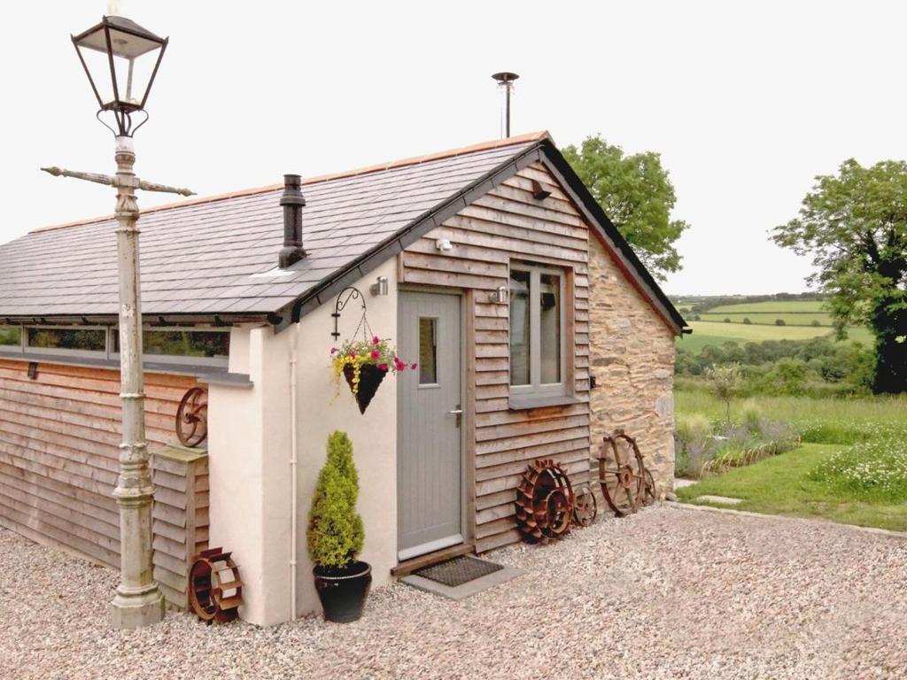 un pequeño cobertizo con una puerta y una luz de la calle en Mugwell Barn, en Callington