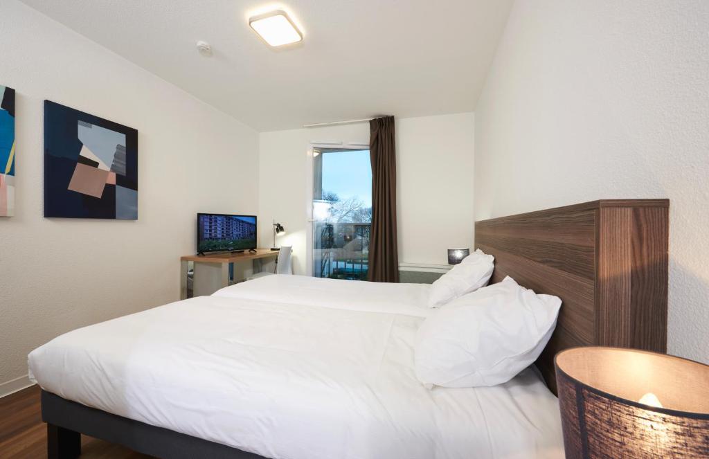 Postel nebo postele na pokoji v ubytování Ténéo Apparthotel Talence - Centre