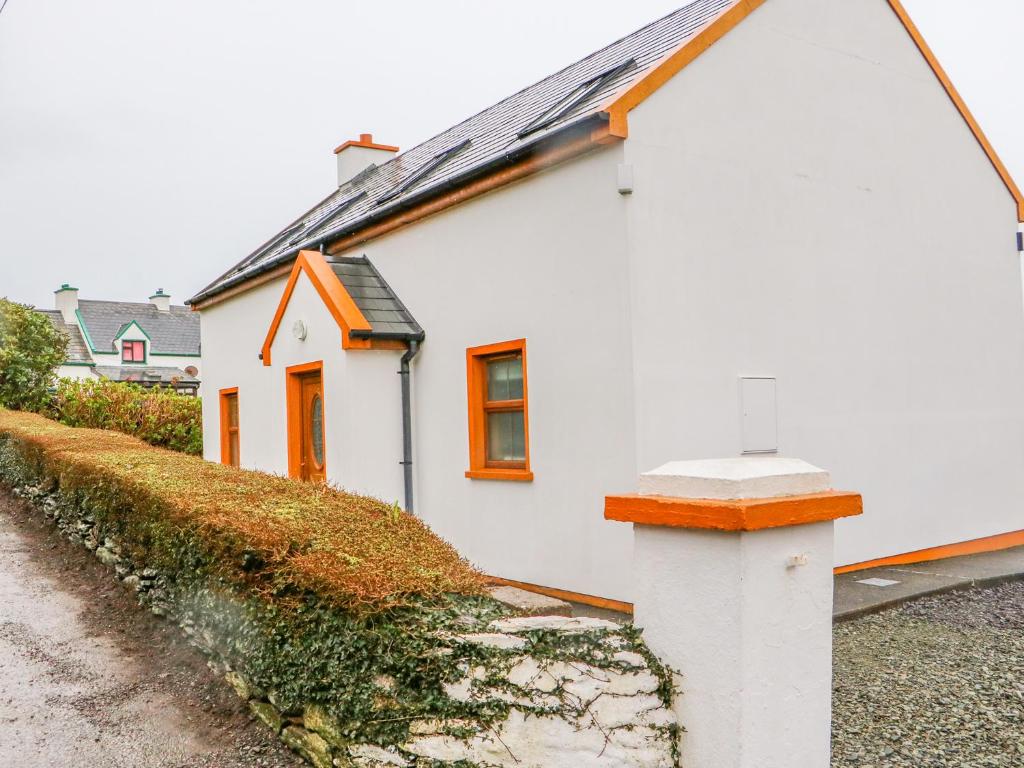 una casa blanca con techo negro en Mary Agnes Cottage en Eyeries