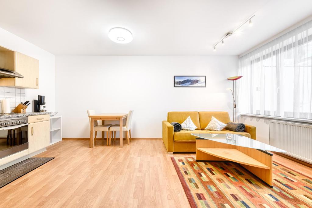 ビュルサーベルクにあるAppartement Ideal by A-Appartmentsのリビングルーム(黄色のソファ、テーブル付)