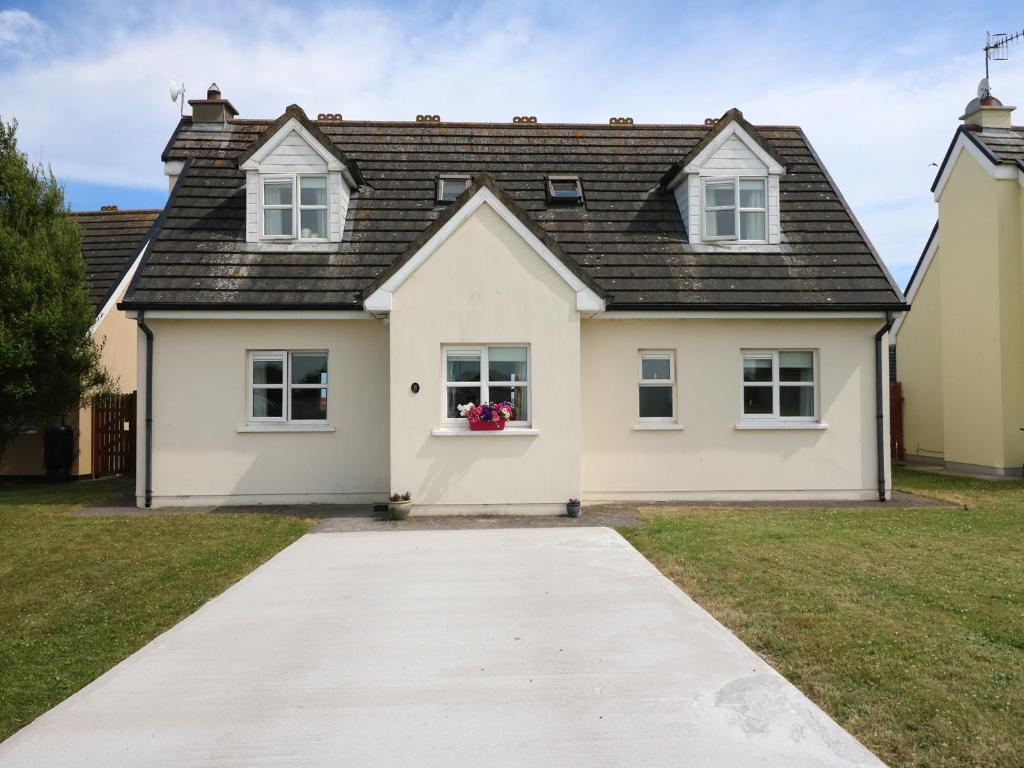 uma casa branca com um telhado preto em Seagaze em Youghal