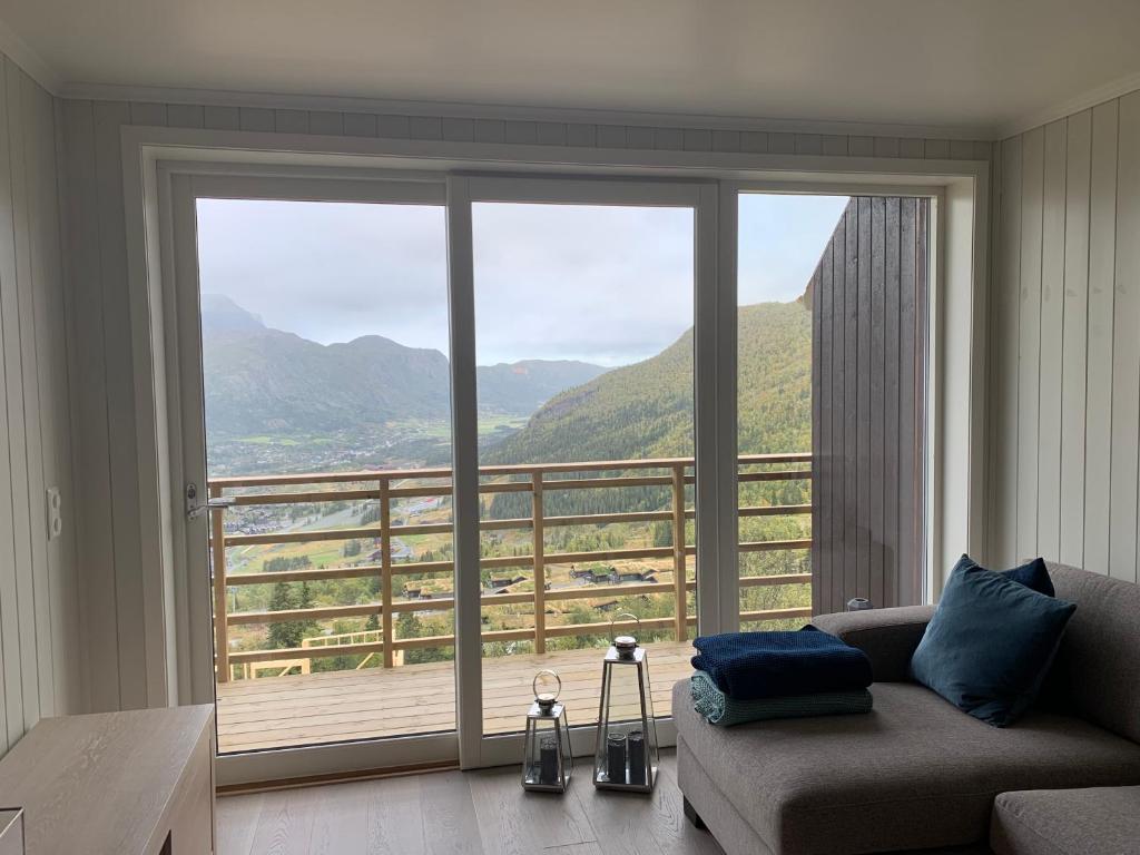 a living room with a couch and a large window at Skarsnuten Panorama 67 in Hemsedal