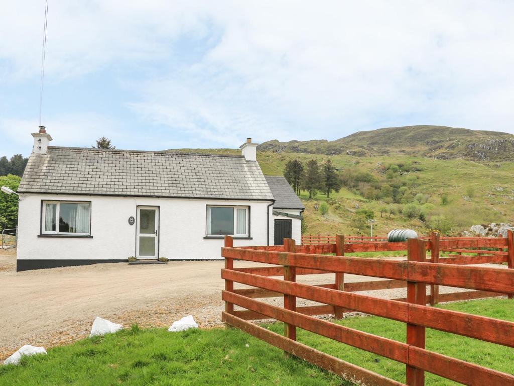 a white house with a fence in front of it at Gapple Cottage in Ballyboe