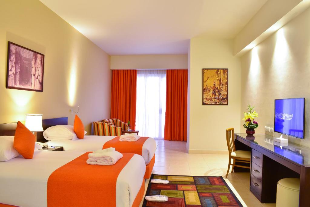 a hotel room with two beds and a television at Parrotel Lagoon Waterpark Resort in Sharm El Sheikh