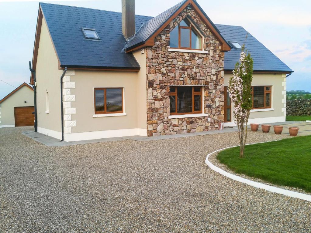 a stone house with a gravel driveway at A Country View Cottage in Mira
