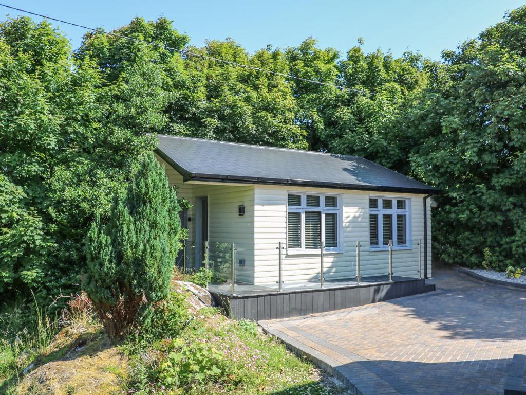 una piccola casa bianca in mezzo agli alberi di Hidden Gem Cabin a Dungloe