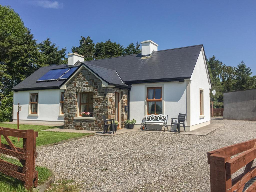 a white house with a black roof at Cloonkee Cottage in Crossmolina