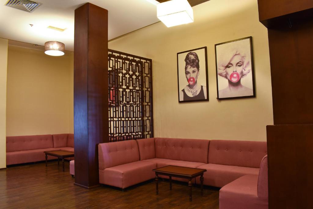 a waiting room with a couch and two pictures on the wall at Parrotel Lagoon Waterpark Resort in Sharm El Sheikh