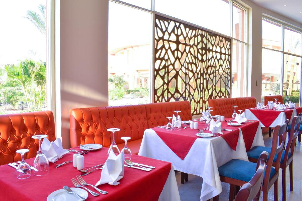 a dining room with red and white tables and chairs at Parrotel Lagoon Waterpark Resort in Sharm El Sheikh