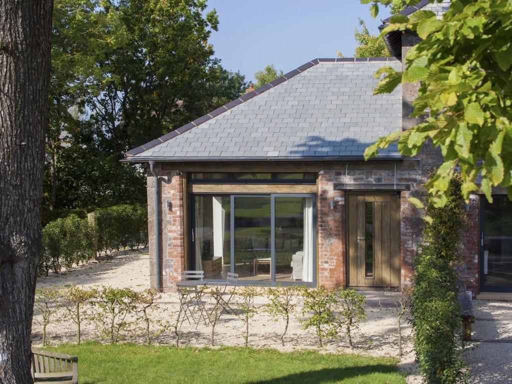 a brick house with a large sliding glass door at Grooms Cottage in Talaton
