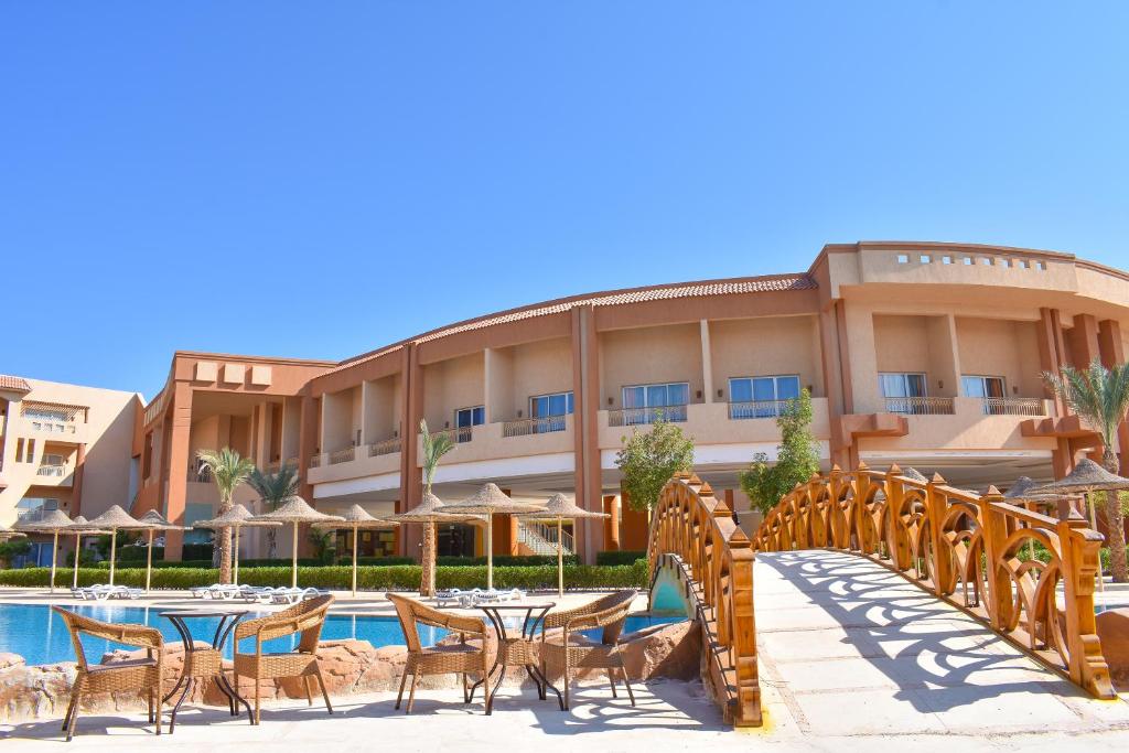 a resort with tables and chairs and a pool at Parrotel Lagoon Waterpark Resort in Sharm El Sheikh