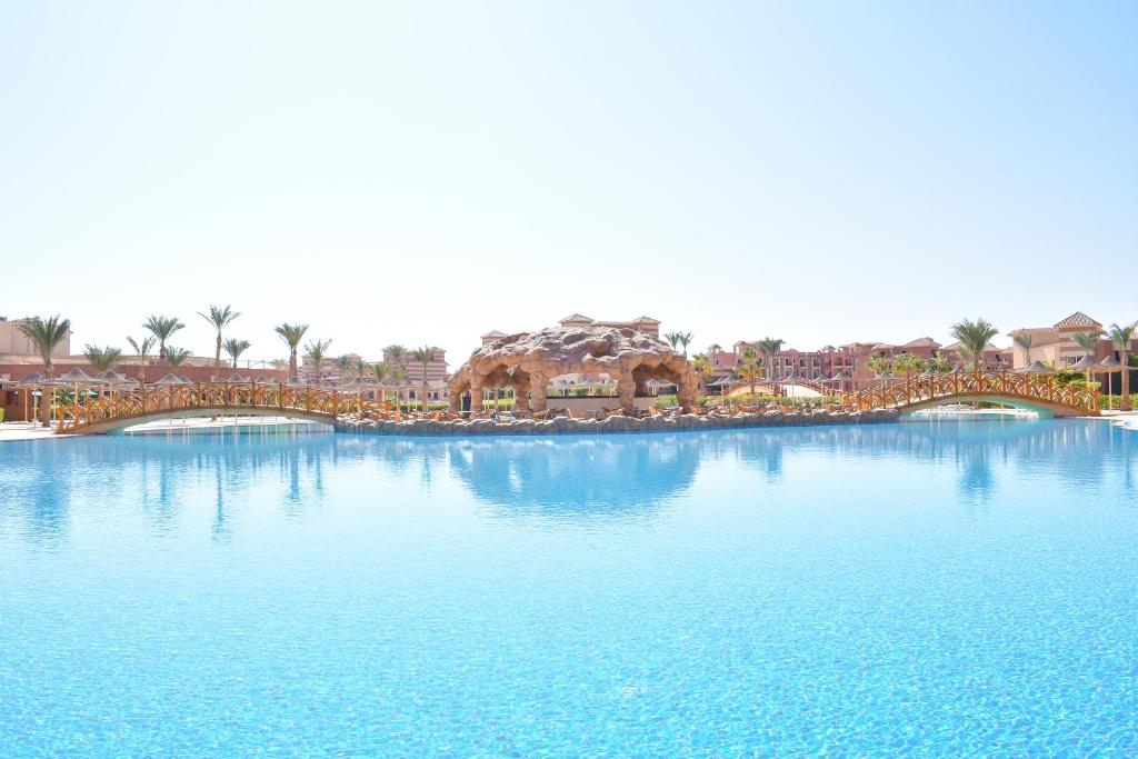a large pool of water with a resort in the background at Parrotel Lagoon Waterpark Resort in Sharm El Sheikh