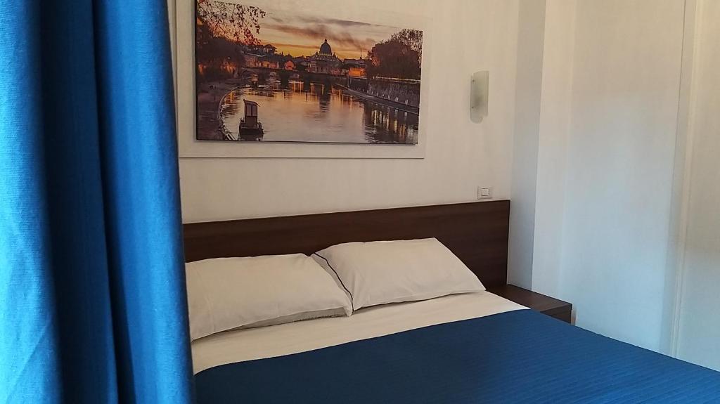 ローマにあるローマ マイ ホーム B＆Bの青いカーテンと絵画が備わる客室のベッド1台