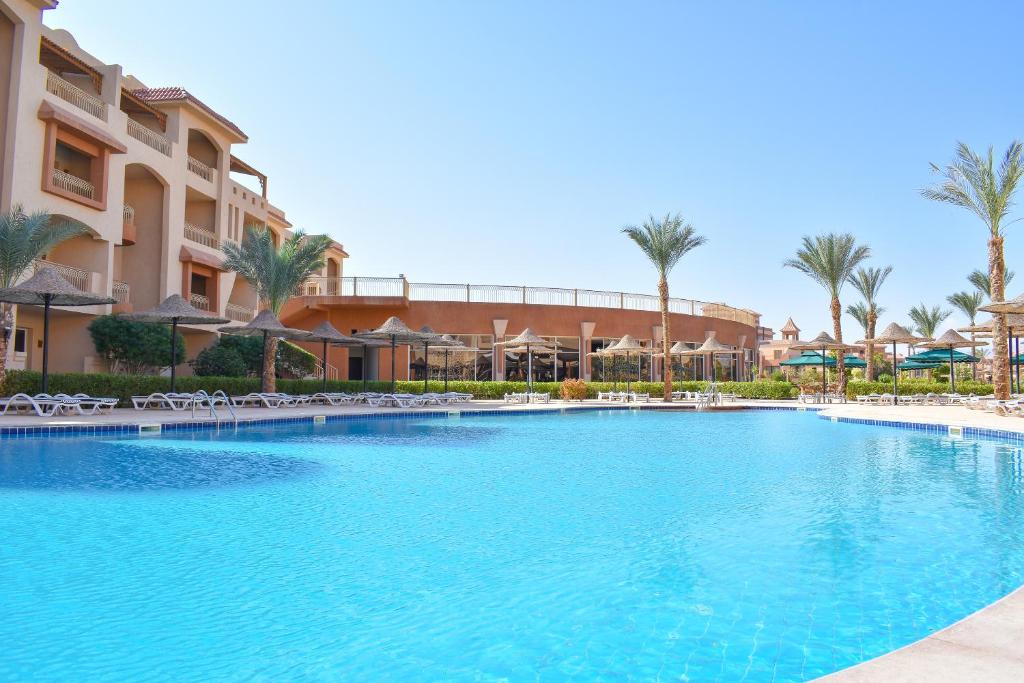 a large swimming pool at a resort with palm trees at Parrotel Lagoon Waterpark Resort in Sharm El Sheikh