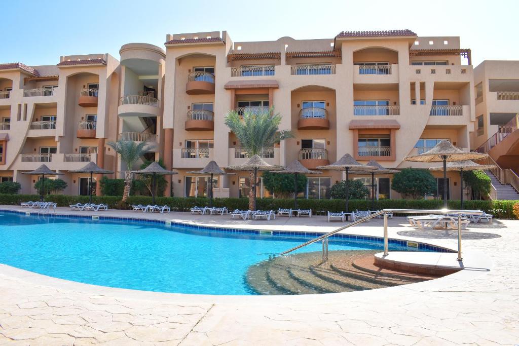 a hotel with a swimming pool in front of a building at Parrotel Lagoon Waterpark Resort in Sharm El Sheikh