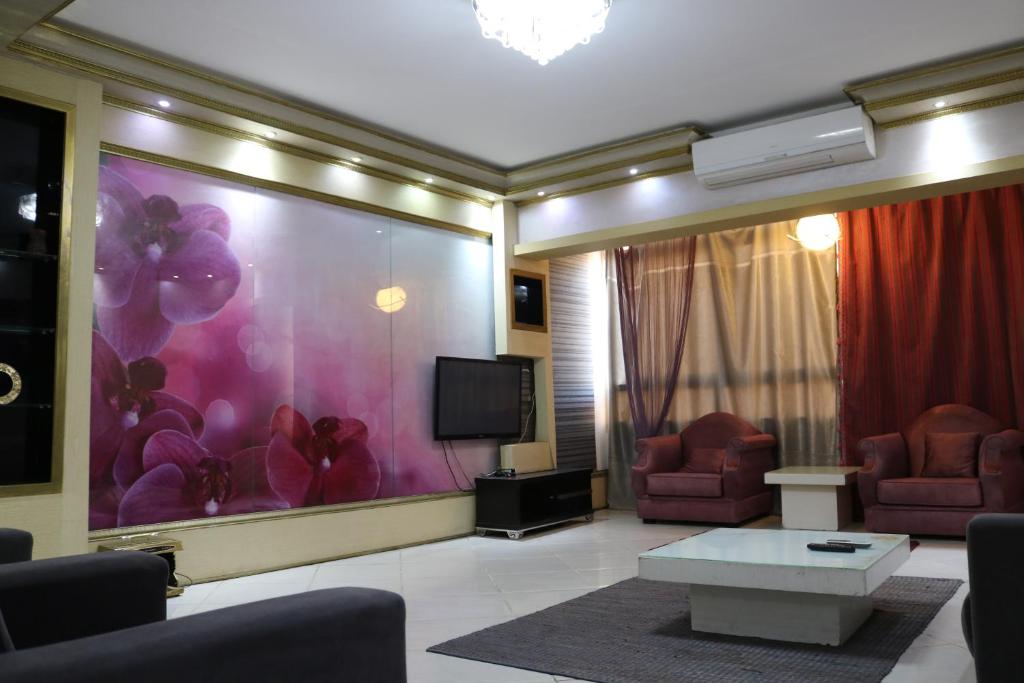 a living room with a tv and two chairs at Apartment at Milsa Nasr City, Building No. 35 in Cairo