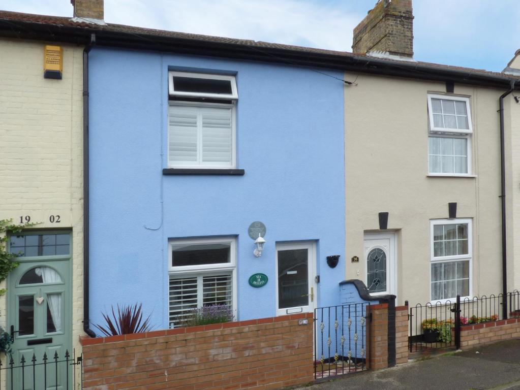 a blue house with a fence in front of it at Sea Breezes in Lowestoft