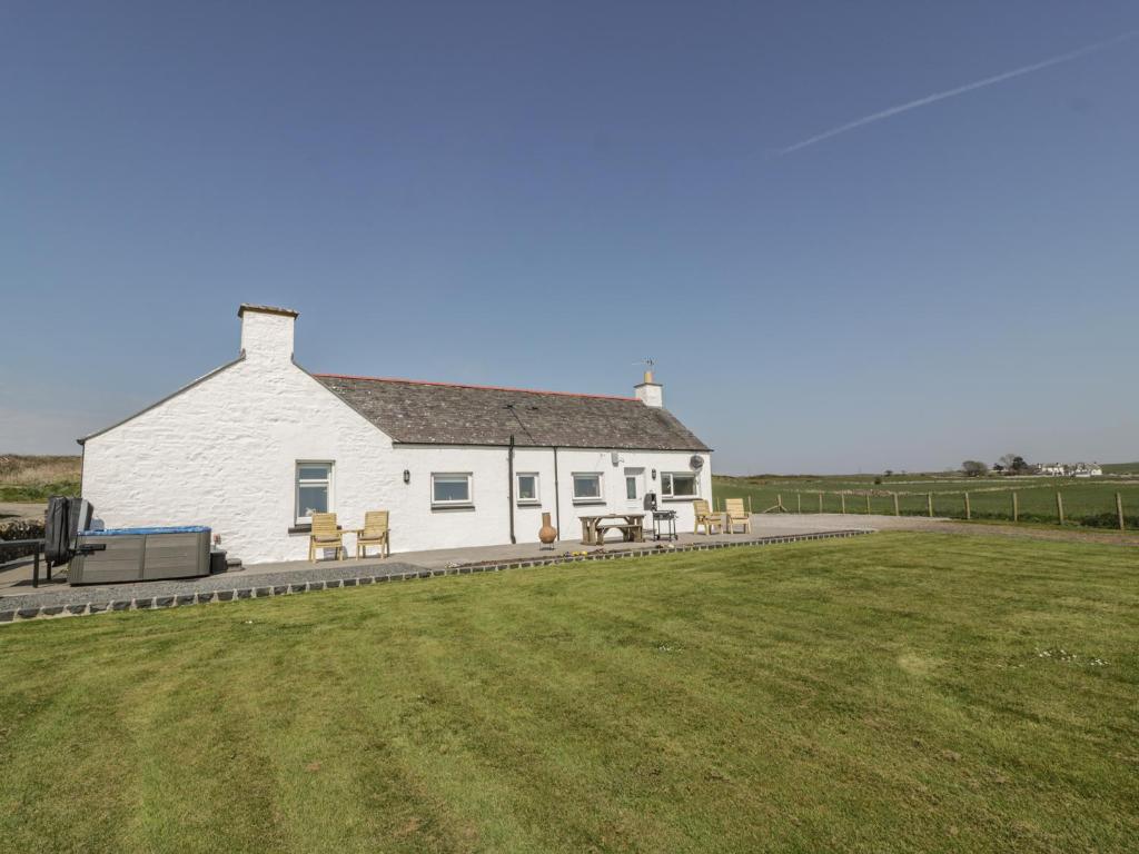 a white house with a lawn in front of it at Longforth Farm Cottage in Gillespie